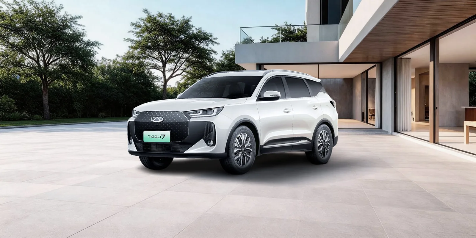 Chery Tiggo 7 w kolorze białym, widok od przodu pod kątem trzy czwarte, w tle nowoczesny dom i drzewa